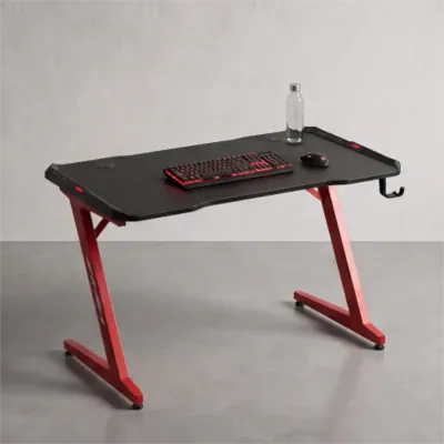 Bureau gaming noir et rouge à piètement en Z avec support de casque et clavier rétroéclairé.