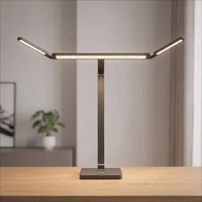 Lampe de bureau LED articulée en bois allumée posé sur un bureau.