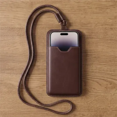 Pochette de téléphone tour de cou en cuir marron avec cordon ajustable.