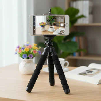 Téléphone posé sur trépied montrant une photo de la plante, de la tasse et du livre posé sur la table