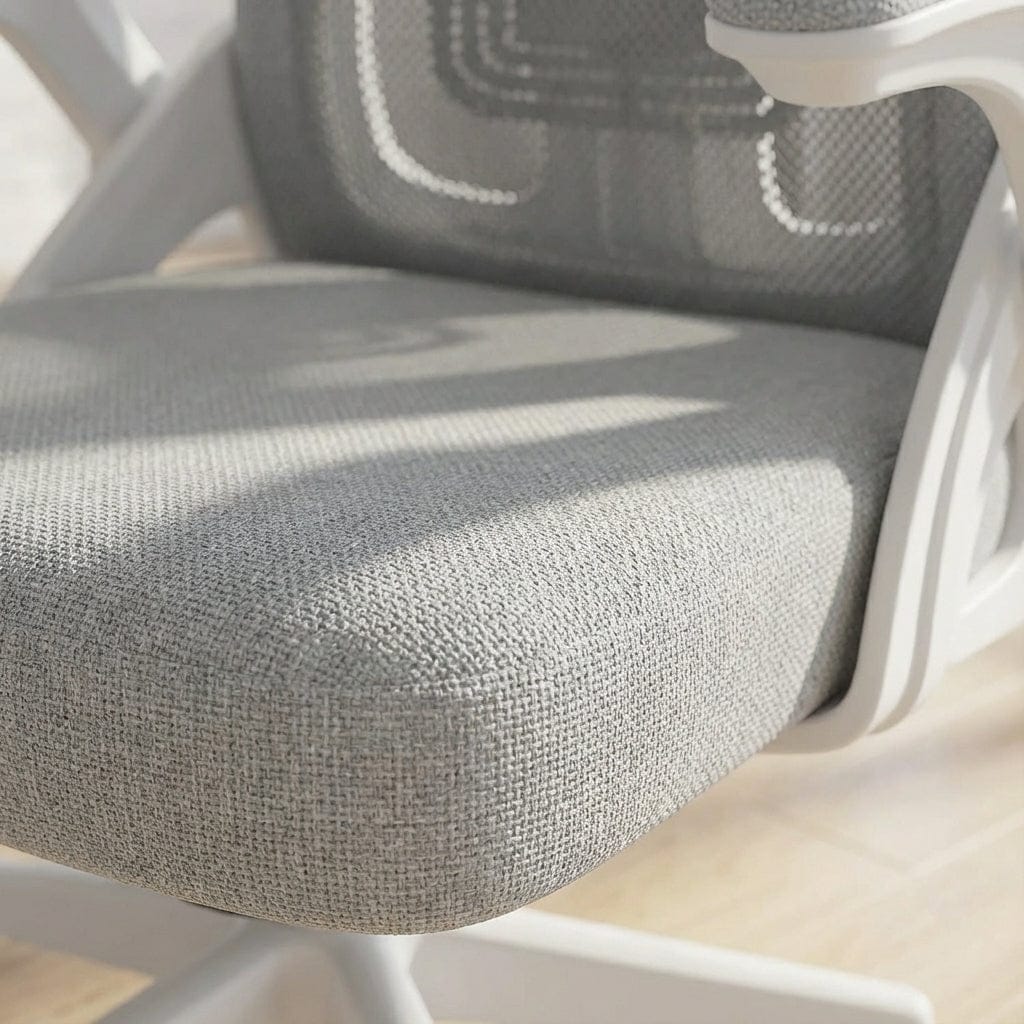 Vue rapprochée de l'assise rembourrée en tissu gris d'une chaise de bureau, avec des accents de structure blanche.
