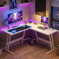 Vue d'ensemble du bureau d'angle blanc KRYON 130x130 avec setup gaming, double écran et éclairage LED RGB.