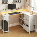 Bureau d'angle blanc ZENITH 140x100 montrant les étagères de rangement latérales et les tiroirs en tissu gris.