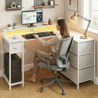Femme travaillant sur le bureau d'angle blanc ZENITH, illustrant l'ergonomie de la rehausse écran et l'espace de travail.