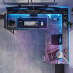 Vue de dessus d'un bureau d'angle modulable avec éclairage LED RGB, double écran et multiprise intégrée pour le gaming et le télétravail.