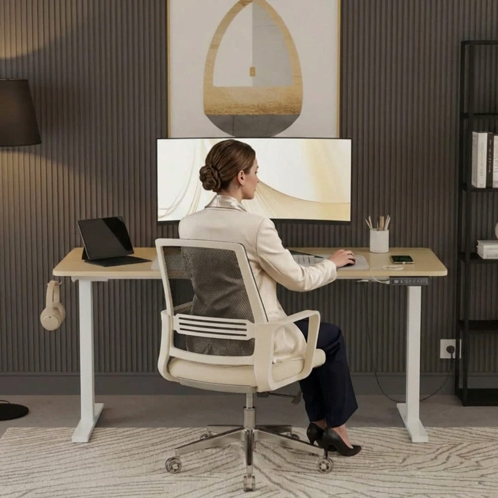 Femme travaillant assise sur un bureau assis-debout électrique réglable avec écran incurvé et chaise ergonomique blanche.