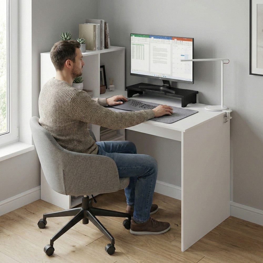 Homme travaillant sur un bureau blanc LYRAX 120x60 avec écran, clavier et étagères de rangement.