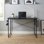 Bureau bois MDF compact noir au design industriel avec ordinateur portable, lampe et plante dans un intérieur moderne.