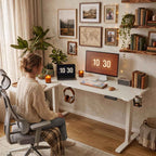 Aménagement chaleureux et chaleureux d'une pièce avec une femme travaillant confortablement sur le bureau d'angle assis-debout blanc Vertex Pro.