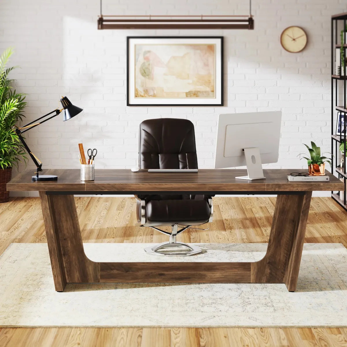Bureau en bois Le Colosse vu de face, aménagé en espace de direction lumineux avec un fauteuil en cuir noir et un mur en briques blanches.