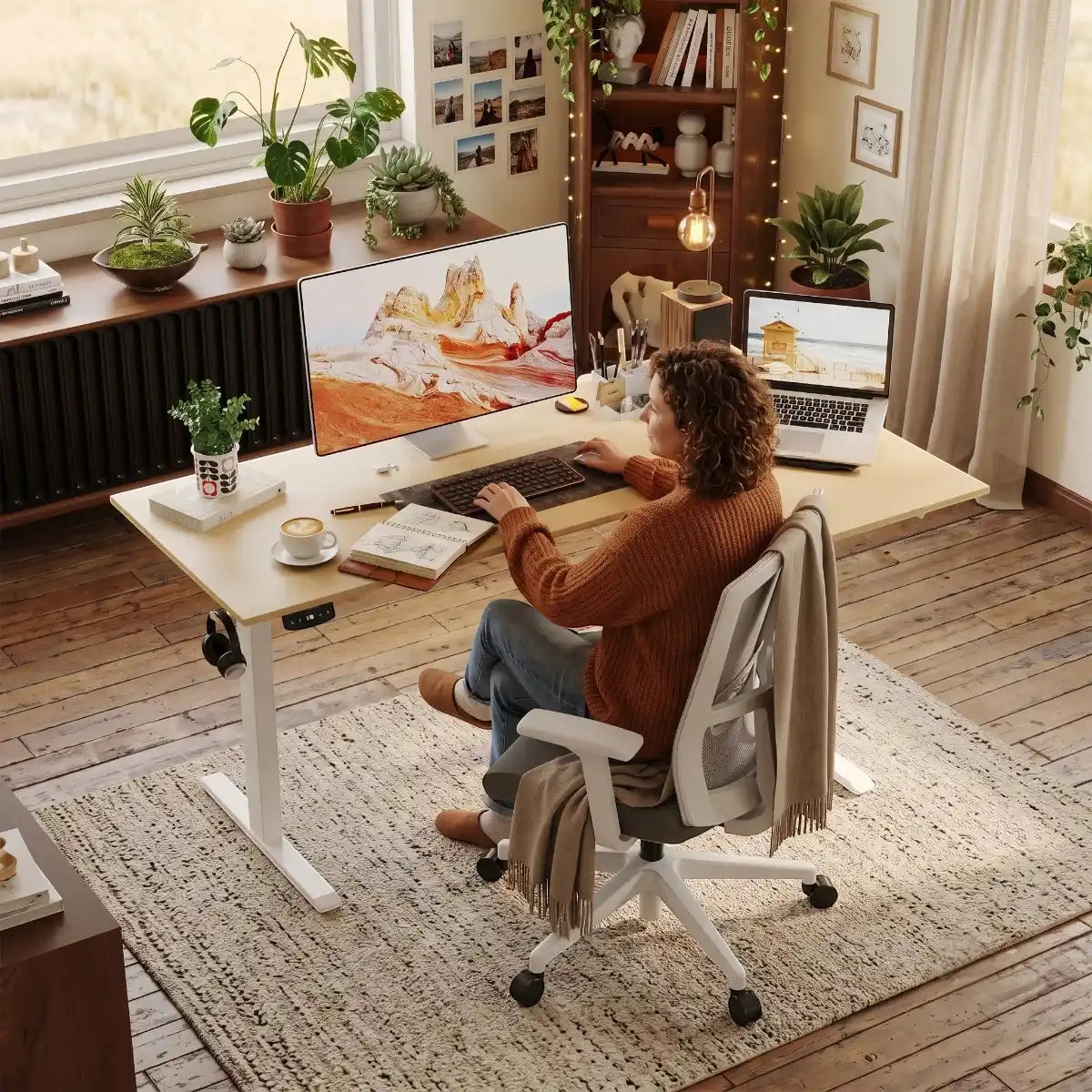 Femme installée devant ses écrans sur le bureau d'angle ergonomique Kinetik-L dans un décor de bureau cosy et chaleureux.