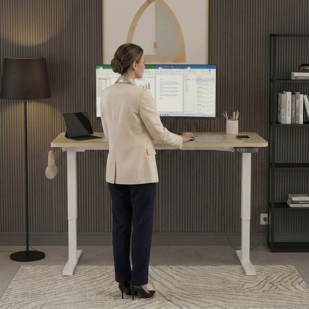Femme en position de travail debout utilisant un bureau réglable en hauteur électrique avec fonction mémoire.