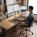 Homme travaillant sur une chaise de bureau ergonomique sans accoudoirs face à un grand bureau en bois.