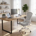 Chaise de bureau grise et blanche dans un bureau moderne avec étagères et bureau en bois.