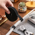 Mise en scène de l'enrouleur de câbles Roll Nexus en nylon noir sur un bureau de travail pour un setup épuré.