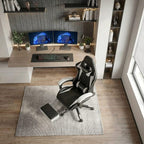 Vue de haut d'un fauteuil gaming noir et blanc avec son repose-pieds rétractable devant un bureau moderne.