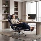 Femme en tenue professionnelle assise dans le fauteuil de bureau de direction noir, se relaxant, les pieds posés sur le repose-pieds déployé. Montre le fauteuil incliné en position de détente dans un bureau moderne.