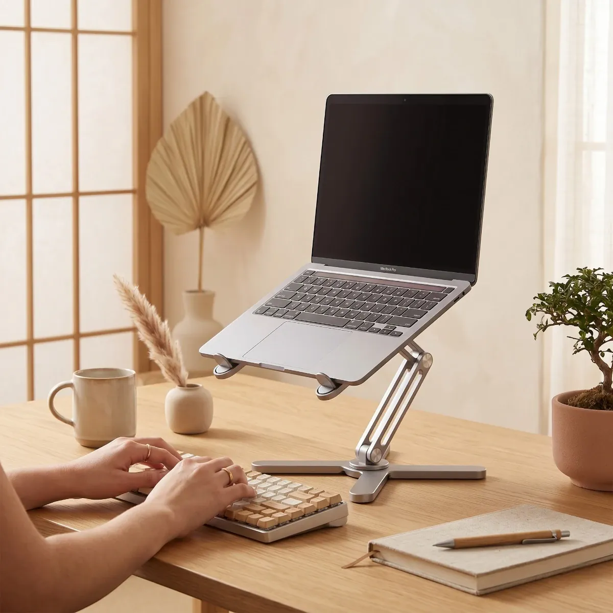 Jeune femme travaillant avec une posture droite idéale, tapant sur un clavier devant son ordinateur surélevé par le support Bureau Cosy.