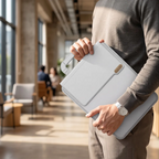 Homme portant la pochette ordinateur MorphoDesk gris nuage à la main avec sa poignée rétractable dans un espace de travail nomade.