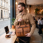 Homme tenant le porte-documents homme Bifolio marron à la hand dans un café, format mallette.