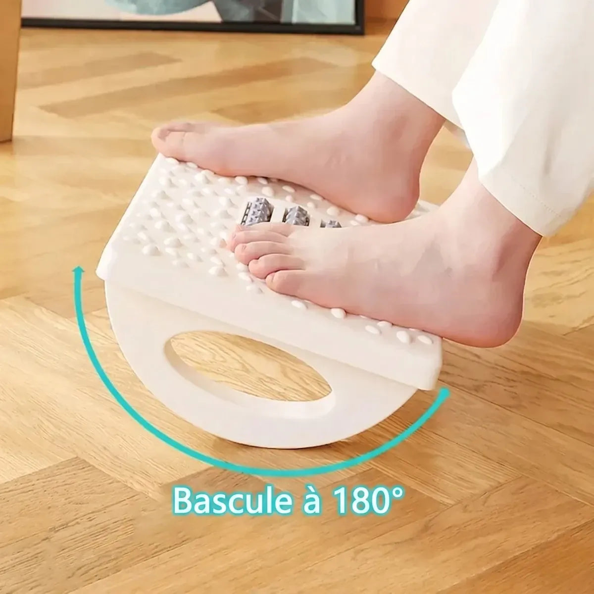 Gros plan de pieds nus posés sur un repose-pieds ergonomique à bascule blanc. L'image montre la surface texturée avec des picots de massage, des rouleaux centraux pour le massage des pieds, et une flèche bleue en arc avec le texte 'Bascule à 180°' indiquant sa fonction de balancement dynamique.
