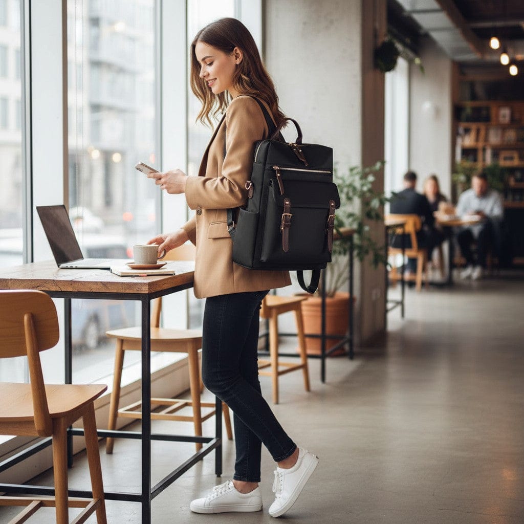 Femme active portant à l'épaule le sac à dos femme ordinateur Sienna noir dans un espace de coworking moderne.