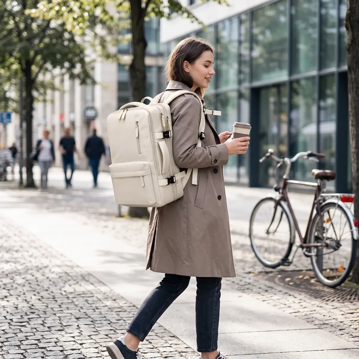 Femme élégante en trench-coat marchant en ville et portant le sac à dos ordinateur femme AeroPro.