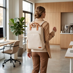 Femme élégante portant le sac à dos ordinateur femme Aura au dos dans un bureau moderne et lumineux.