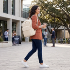 Femme d'affaires en veste terracotta portant le sac à dos ordinateur femme Aurelia dans un cadre urbain chic.