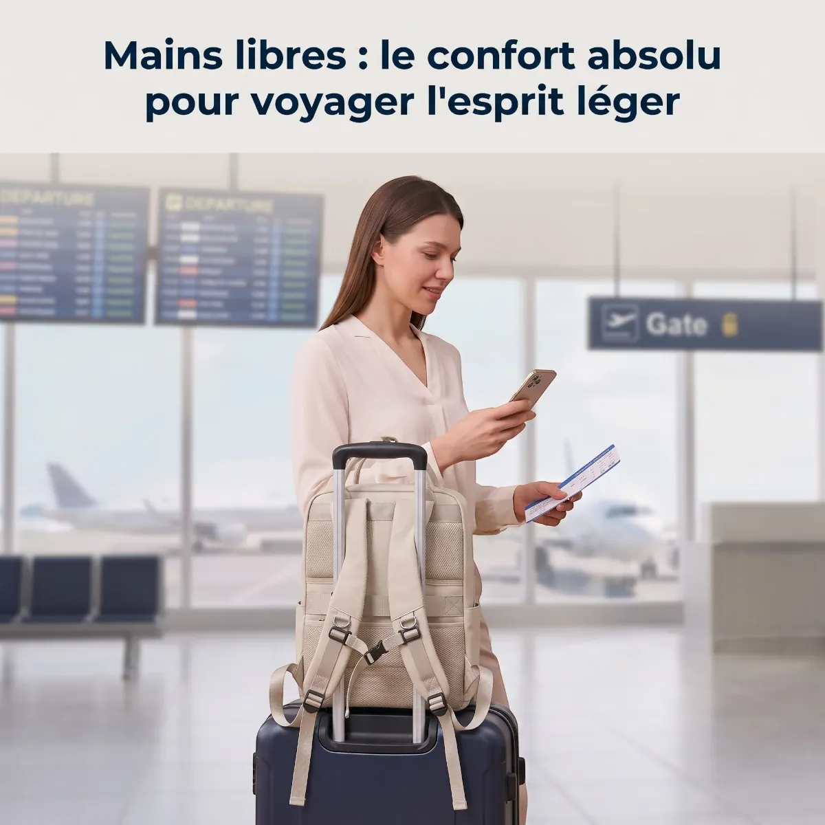 Sac à dos ordinateur femme Kora fixé à une valise par son passant trolley dans un aéroport.