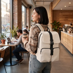 Femme portant le sac à dos ordinateur Zéphira beige dans un café