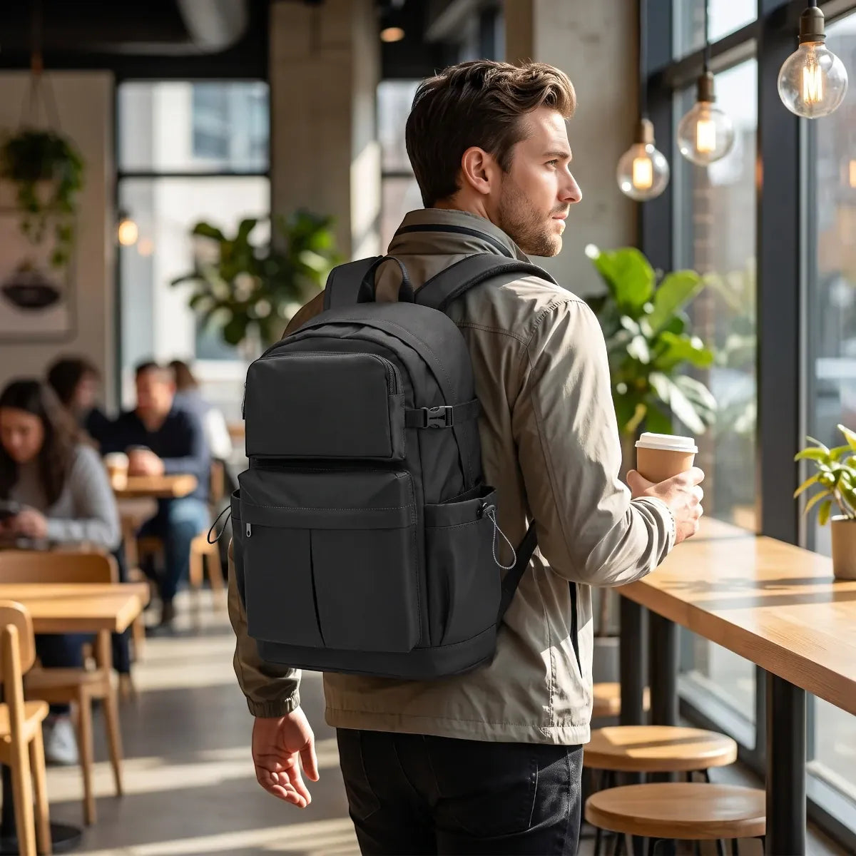 Homme portant le sac à dos ordinateur homme JetLayer dans un café urbain