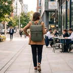 Une femme portant le Sac à Dos Organisé pour Ordinateur Portable (Vert Olive) marchant dans un environnement de déplacement urbain