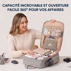 Femme souriante assise à un bureau, ouvrant complètement un sac à dos gris moderne avec une ouverture à 360°. L'intérieur du sac est ultra-organisé avec des compartiments dédiés contenant des vêtements pliés, un ordinateur portable, des articles de toilette, un passeport et des fournitures de bureau, accompagné d'un texte français vantant la capacité incroyable et l'ouverture facile.