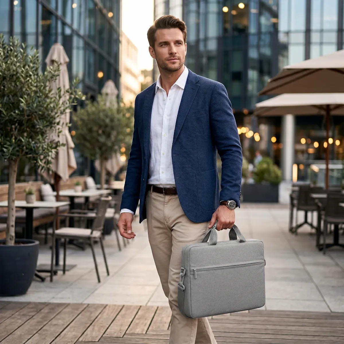 Homme d'affaires en costume portant à la main la sacoche ordinateur homme AeroStride en milieu urbain.