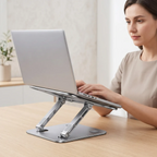 Une femme travaille sur son ordinateur portable installé sur le support AeroSteel Pro de Bureau Cosy dans un environnement style Japandi épuré.