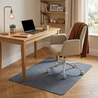 Tapis de sol bureau installé sous un siège ergonomique beige et un bureau en bois clair dans un décor scandinave chaleureux.