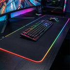 Mise en situation du tapis de souris XXL Lumina Glide Pro dans un setup gaming immersif avec clavier et souris.