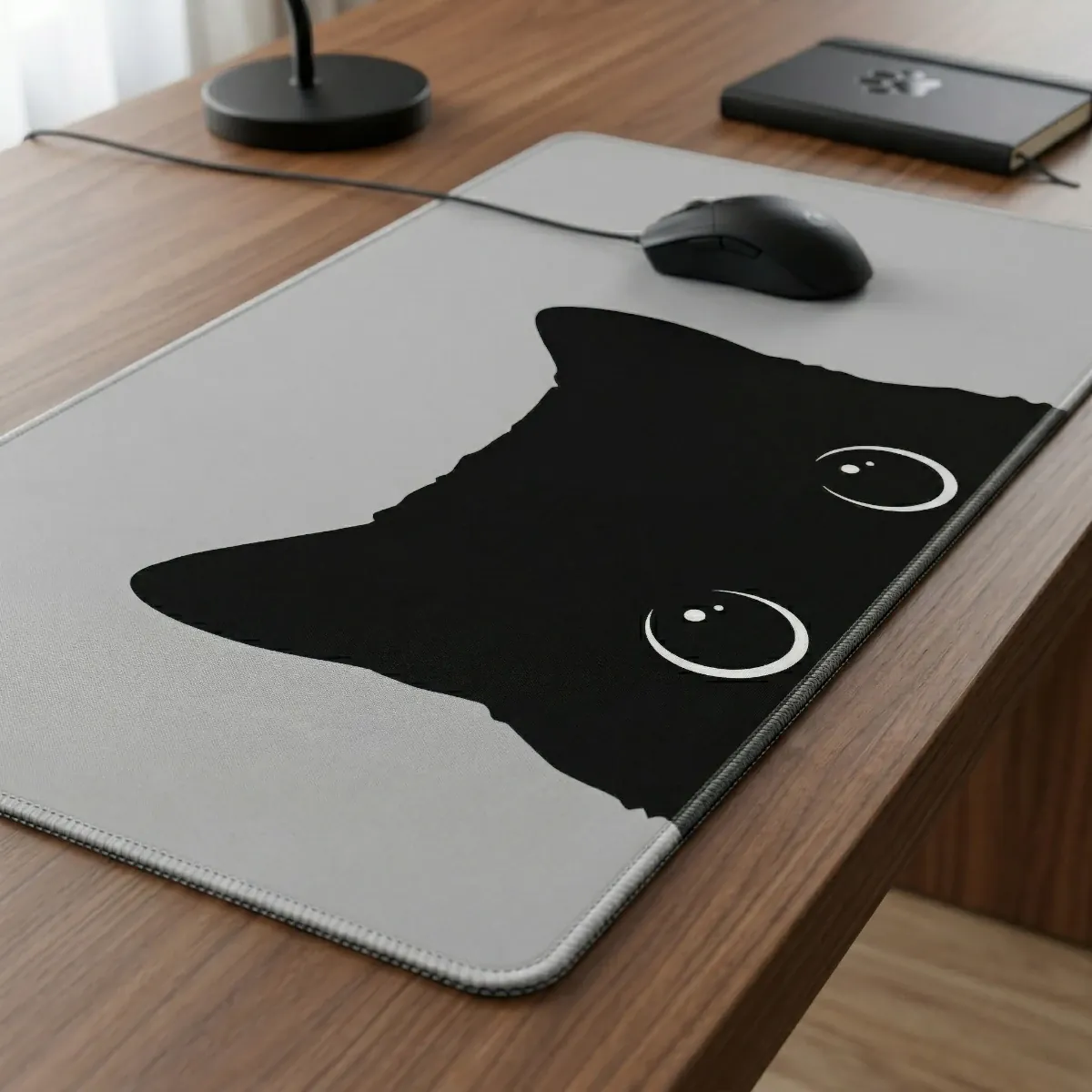 Gros plan en vue 3/4 du tapis de souris Shadow Prowl sur un bureau en bois montrant la précision de la surface.