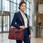 Mannequin en costume bleu portant le tote bag ordinateur femme L’Ambitieuse bordeaux à l'épaule, illustrant un style professionnel et sophistiqué.