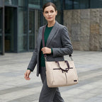 Mannequin femme portant le tote bag ordinateur L'Aérienne 15" en bandoulière à l'extérieur, en marchant dans un décor urbain moderne.