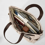 Vue de dessus de l'intérieur ouvert du tote bag ordinateur femme L'Aérienne 15", rempli d'un ordinateur portable, d'une tablette, d'un livre et d'accessoires.